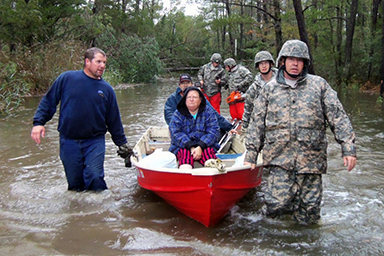 Virginia National Guard Soldiers transport citizens through high water to reach their medium tactical truck for evacuation on Cattail Road in the Mears, Va. area Oct. 30.